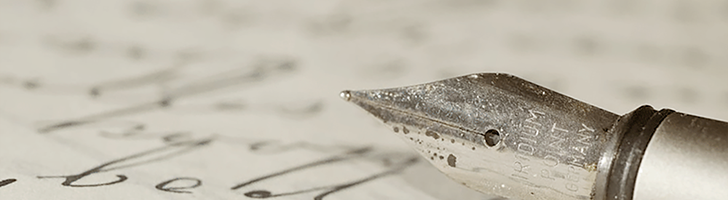 close-up photo of an ink pen with handwriting on a sheet of paper