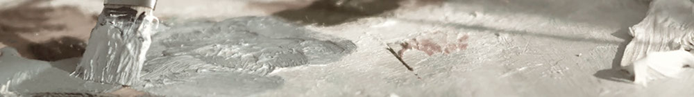 close-up photo of a paintbrush mixing paint on a wooden palette